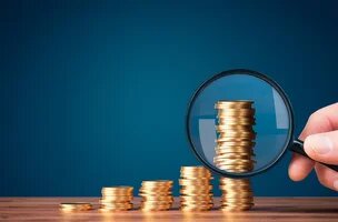 tas de pièces avec loupe dessus